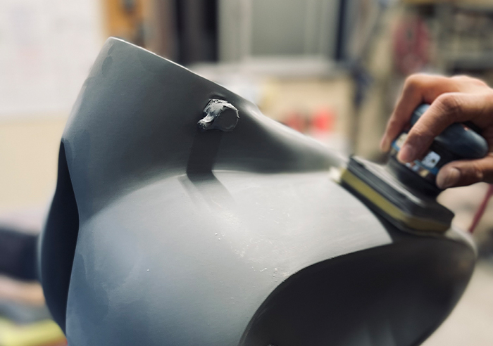 乾燥後のサーフェーサーを研磨し、塗装仕上がりを左右する表面を整える作業