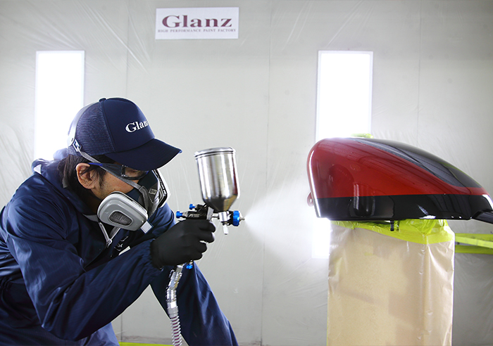 専用塗装ブースでSTANDOX塗料を使用し、安定した環境でバイクパーツを塗装する工程