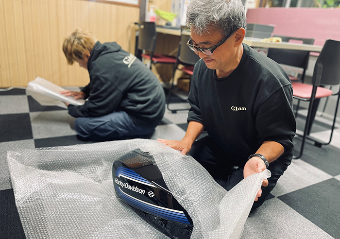 完成したバイクパーツをエアキャップと専用段ボールで梱包し、安全に発送する工程