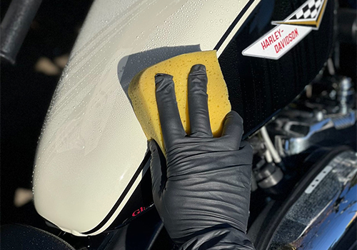 施工前にバイクのボディを洗浄し、汚れを落としている様子