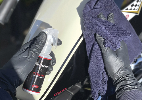 専用クロスにコーティング剤を吹き付けて塗布している様子